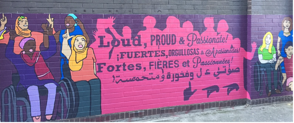 Banner painted on a brick wall with quote "Loud, Proud & Passionate"